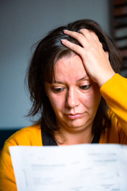 istock Worried woman checking bills at home 1345466816