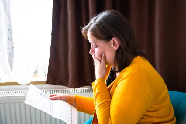 istock Worried woman checking bills at home 1345466887