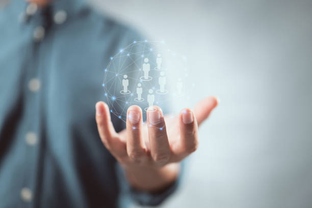 istock Men hand holding a digital sphere filled with wireless connections and human figure representations. 1345468346