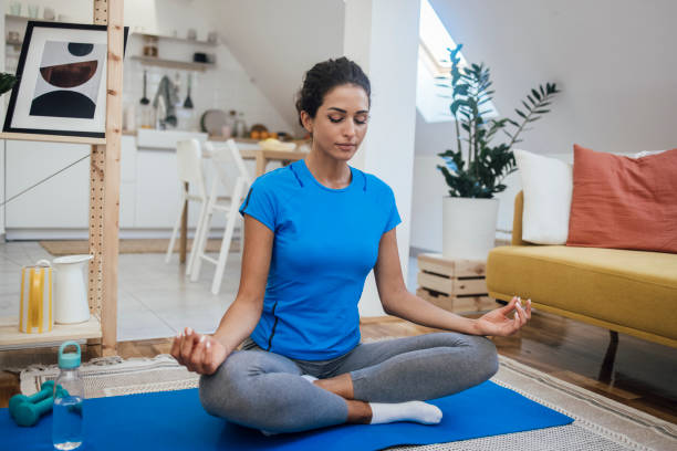 istock Beautiful young woman meditating at home 1345468446