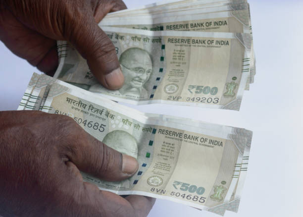 istock Man hand counting five hundred Indian rupee note. High angle view. Close up. White background. 1345472282