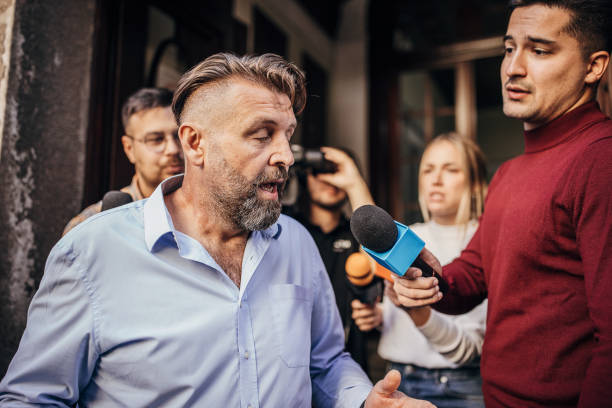 istock Male politician confronted by journalists 1345473148