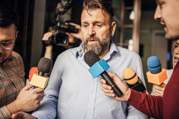 istock Male politician confronted by journalists 1345473163