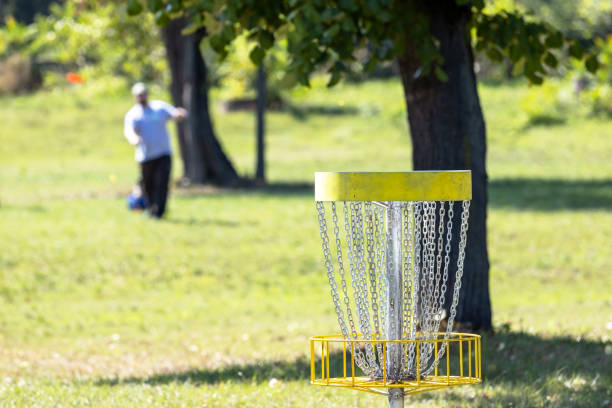 gra w latającego disc golfa w parku, kosz docelowy w centrum uwagi - rules of golf zdjęcia i obrazy z banku zdjęć