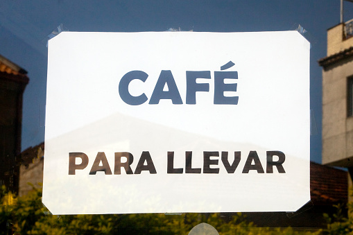 Cafeteria advertisement on glass door. Coffee to take away. Seen in the street, Pontevedra, Galicia, Spain.