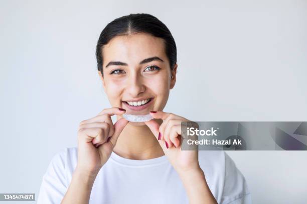 Closeup Of A Girls Hand Putting Transparent Aligner In Teeth Stock Photo - Download Image Now