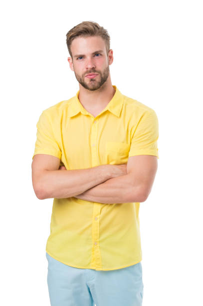 istock Man on calm face posing confidently with folded arms, white background. Man looks attractive in casual yellow linen shirt. Guy with bristle wears casual or formal shirt. Fashion concept 1345474881