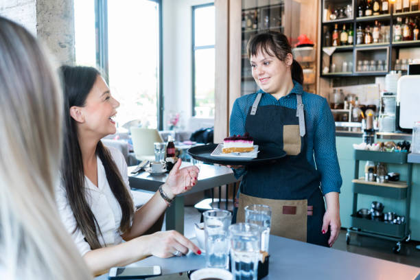 istock Young woman with Down Syndrome working at cafe 1345475819
