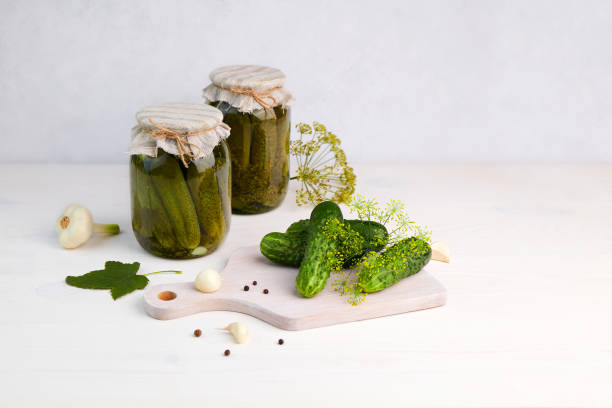 istock Pickled cucumbers in the jars, ingredients for pickling cucumbers: fresh cucumbers, dill, garlic, pepper 1345477620