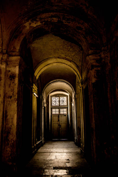 istock A gloomy corridor with a door at the end, from which comes the light 1345481396