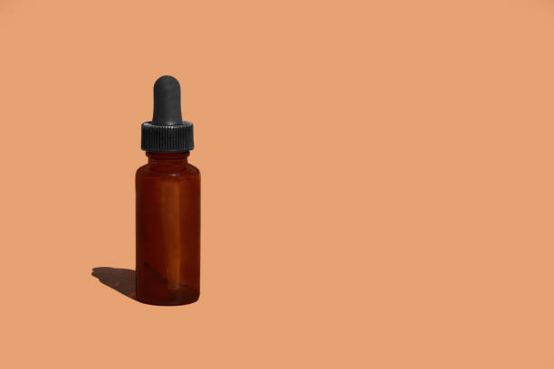 istock A brown bottle with a dropper on a brown background 1345482534