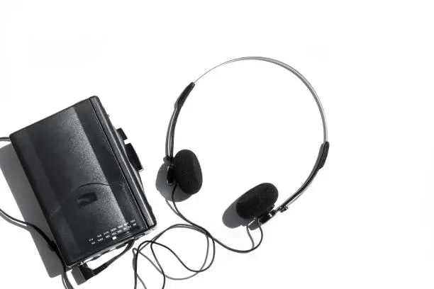 A black cassette player with headphones on a yellow background