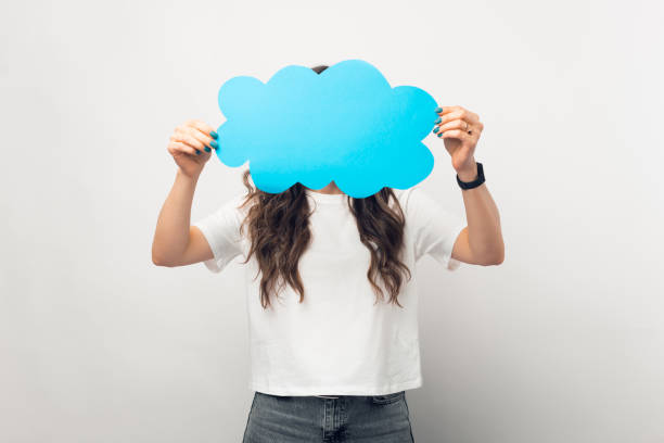 istock Young female is covering her face with the cloud speech bubble she is holding. 1345483685