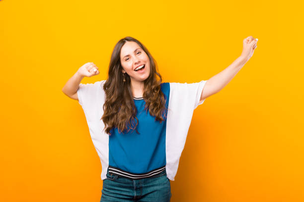 istock Joyful young lady is making the winner gesture while smiling at the camera. 1345483746