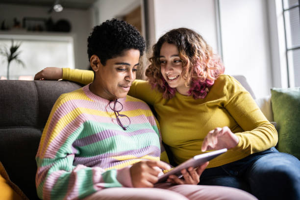 istock Female friends using a digital tablet at home 1345484150