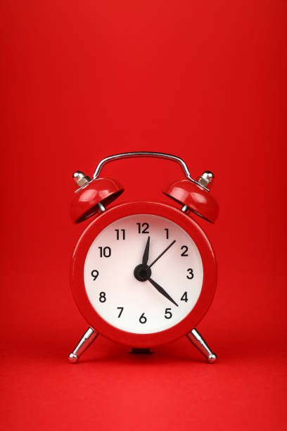 istock Close up one red alarm clock over red background 1345484155