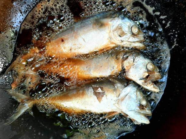 istock Frying Mackerel fish in iron cooking pan. 1345484929