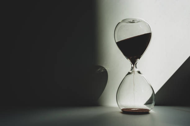 istock Time is measured by an hourglass in the twilight illuminated by sunlight. 1345485257