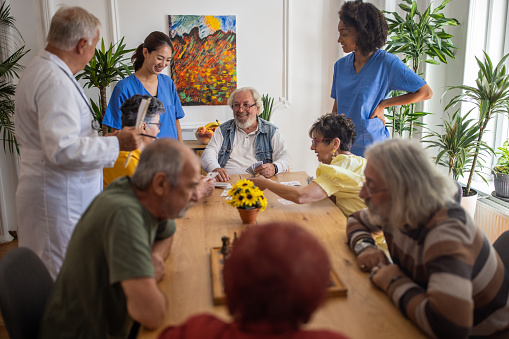 Personas mayores felices jugando a las cartas en un hogar de ancianos photo