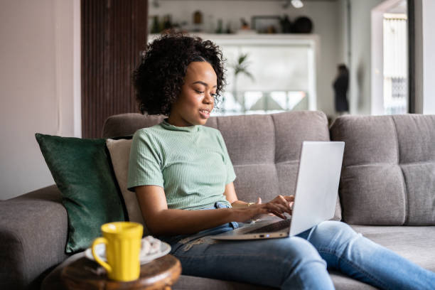 istock Young woman using a laptop at home 1345486637
