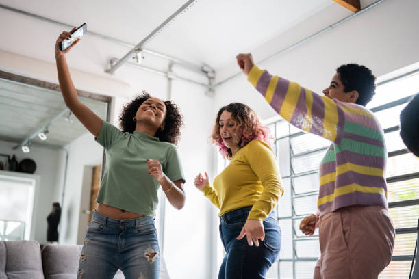 istock Friends filming themselves dancing (or on a video call) at home 1345486658