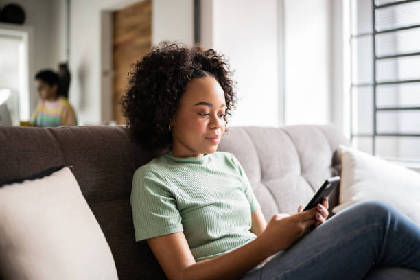 istock Young woman using a smartphone at home 1345486707