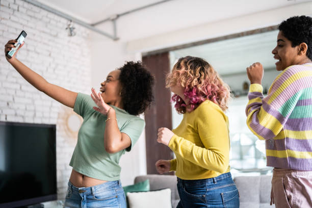istock Friends filming themselves dancing (or on a video call) at home 1345487618