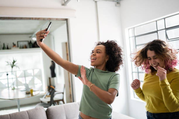 istock Friends filming themselves dancing (or on a video call) at home 1345487620