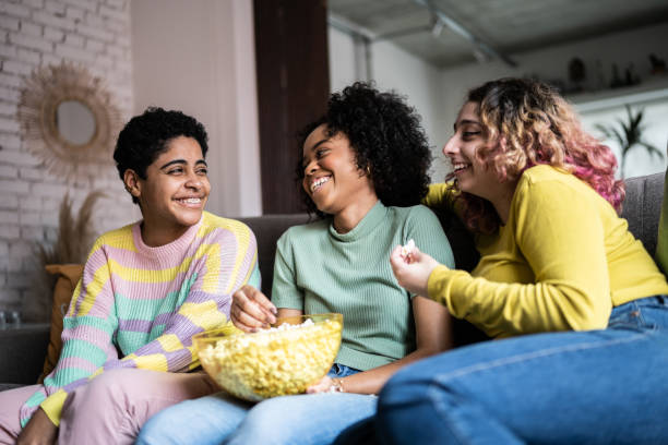 istock Friends watching TV and eating popcorn at home 1345487635