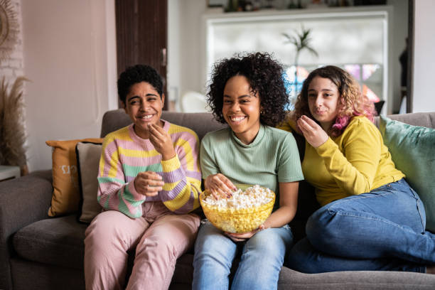 istock Friends watching TV and eating popcorn at home 1345487674