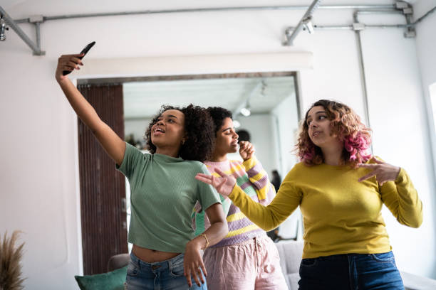 istock Friends filming themselves dancing (or on a video call) at home 1345487675
