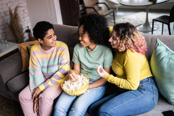 istock Friends watching TV and eating popcorn at home 1345487748