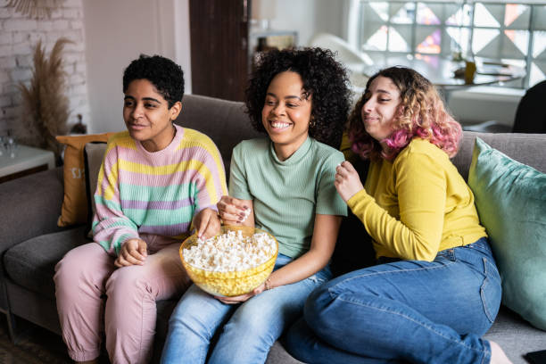 istock Friends watching TV and eating popcorn at home 1345487794