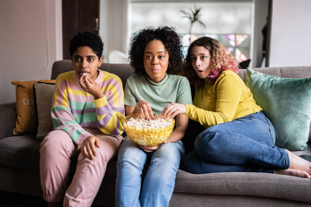 istock Friends watching TV and eating popcorn at home 1345487832