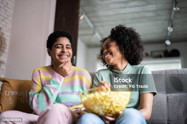 Friends Watching Tv And Eating Popcorn At Home Stock Photo - Download Image Now - Television Set, Popcorn, Watching