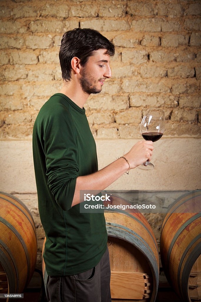 Young vintner'degustación de vino tinto en una antigua bodega - Foto de stock de Viejo libre de derechos