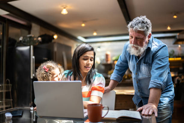 istock Father helping daughter using the laptop at home 1345489232