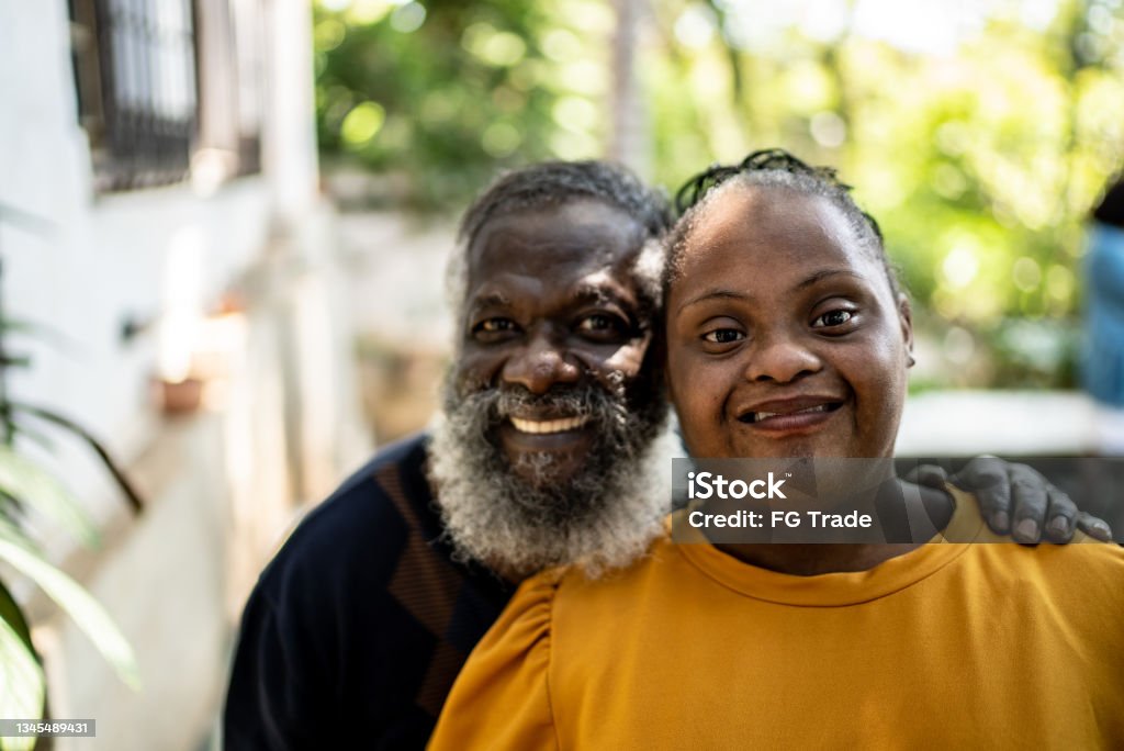 Portrait of a father and his daughter with special needs at home Disability Stock Photo