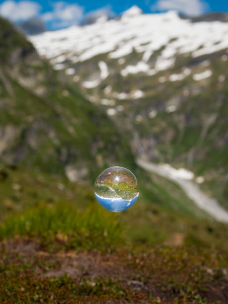 istock Glass ball floating over pasture in the alps 1345489521