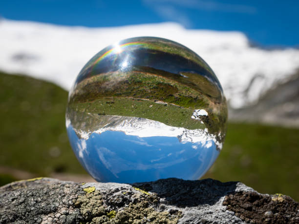 istock Glass sphere lying on a rock in the alps 1345489628