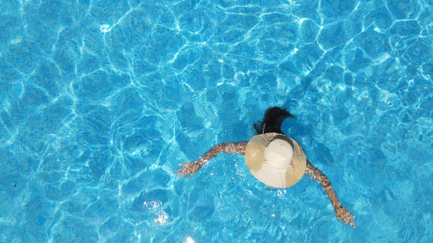 istock Young  woman in bikini in a lonely pool 1345489914