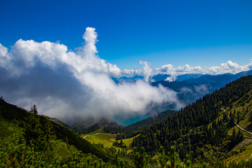 View above clouds moving over lake walchensee in the bavarian alps
