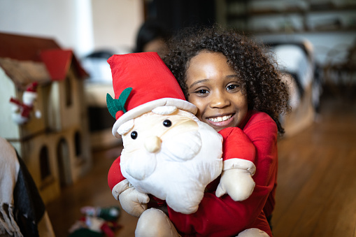 Portrait of a girl with a Santa Claus doll at home