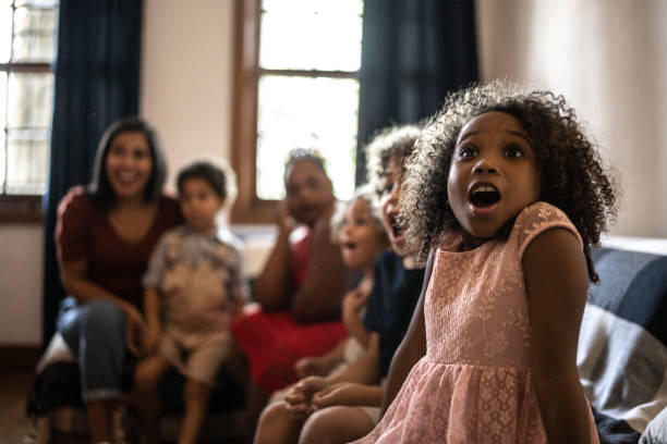 bambini sorpresi il giorno di natale (o guardando la tv) a casa - riunione di famiglia foto e immagini stock