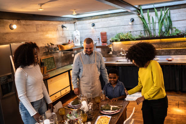 istock Family setting table together for Christmas lunch or dinner at home 1345494751