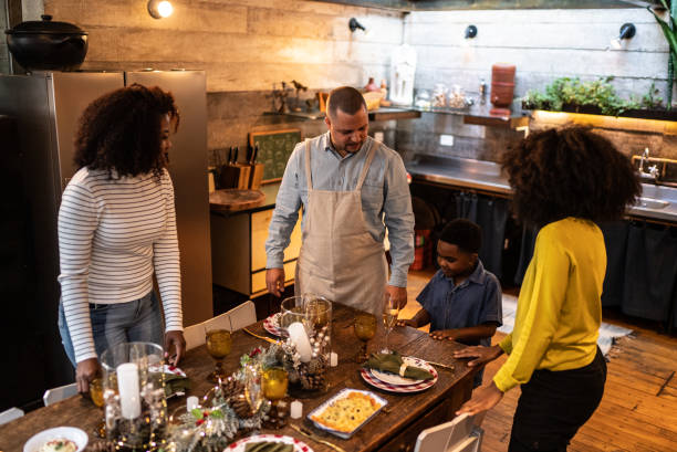 istock Family setting table together for Christmas lunch or dinner at home 1345494773