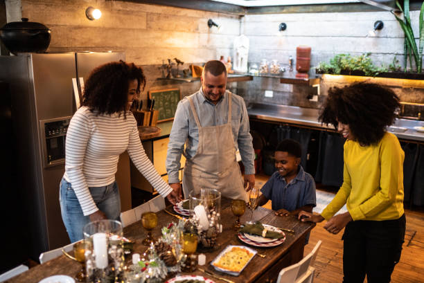 istock Family setting table together for Christmas lunch or dinner at home 1345494842
