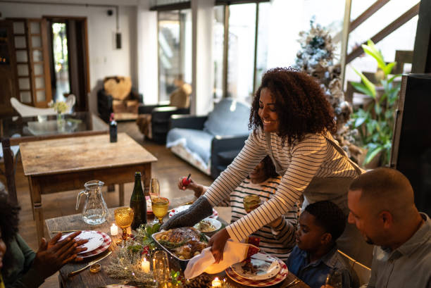 mujeres medianas adultas que sirven la cena de navidad en casa - 5 month old fotografías e imágenes de stock