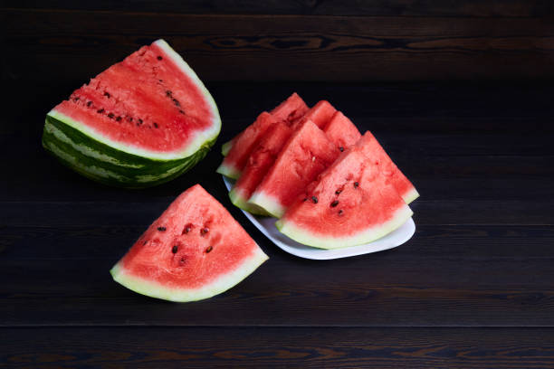 istock Fresh ripe sliced watermelon on dark wooden background 1345495876