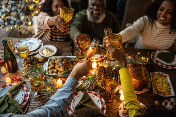 family toasting on christmas dinner at home - glas serviesgoed fotos stockfoto's en -beelden